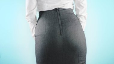 Renkli bir arka plan üzerinde güzel bir iş kadını. yakın çekim etek. Giysi, kod, kalça hareket.