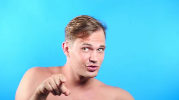 Young man on a colored blue background. portrait. emotions and gestures. close-up. the guy looks at the camera sexually and dances — Stock Photo, Image