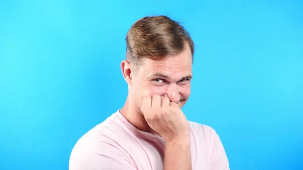 Joven sobre fondo azul. Retrato. emociones y gestos. Primer plano. el chico está mirando sexualmente a la cámara y se propone ir con él . — Foto de Stock