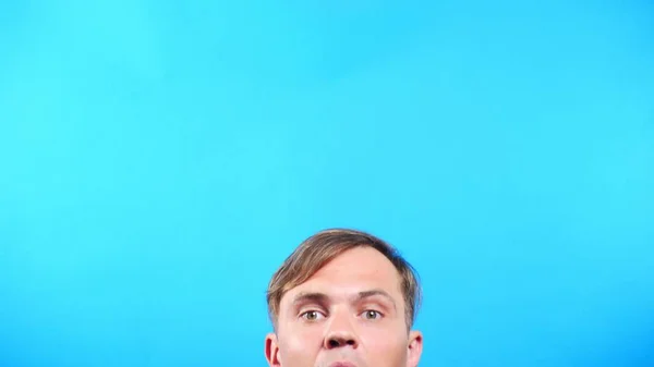 Young man on a colored blue background. portrait. emotions and gestures, close-up. the guy looks in the camera with interest. whats happening . — Stock Photo, Image