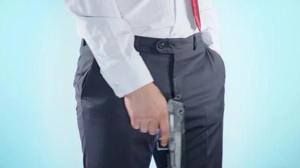 Close-up. Kleurrijke achtergrond. Een jonge man houdt een pistool in zijn handen — Stockfoto