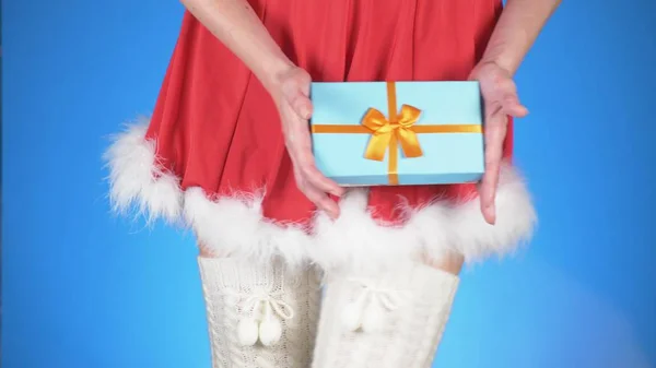 Férias de Natal. jovem mulher atraente em um traje de donzela de neve com um presente, dançando em um fundo azul. close-up — Fotografia de Stock