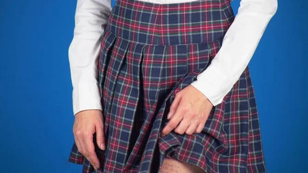 Midsection of teenage girl, cheat sheet written on hips hidden under a skirt. close-up, blue background — Stock Photo, Image