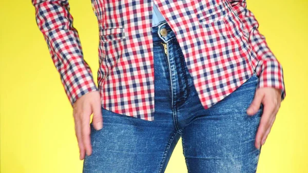 En tjej i jeans med vackra runda skinkor går sexuellt. närbild. — Stockfoto