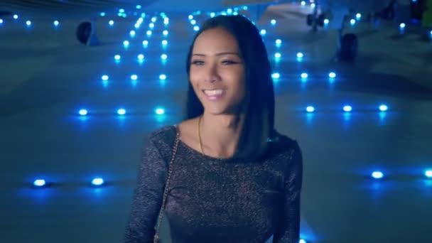 Beautiful Asian girl ladyboy looking at the camera and smiling. Thai transgender model at the airport on the background of an airplane in the evening — Stock Video