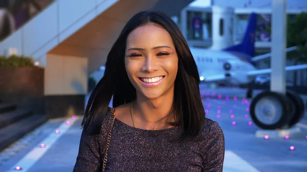 Beautiful blue-eyed asian girl ladyboy looking into the camera and smiling. transgender Thai model at the airport in the background of the aircraft — Stock Photo, Image