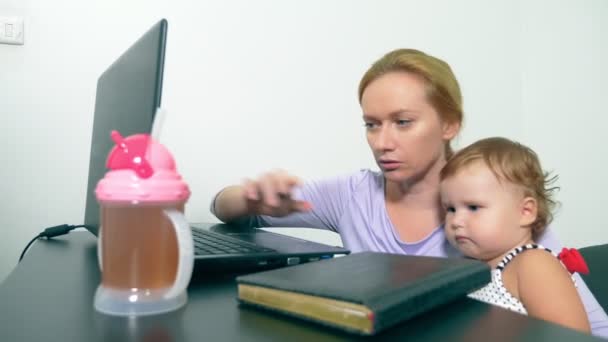 Koncepcja pracy Mama, nieetatowy. szczęśliwą matką, pracy w domu z laptopem, trzymając dziecko w ramionach. — Wideo stockowe