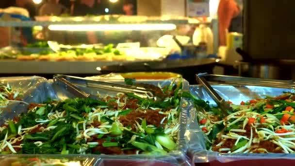 Comida de rua tradicional da Tailândia. Cozinhar pratos nacionais à noite no mercado de comida de rua. close-up . — Vídeo de Stock