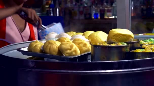 Традиционная уличная еда Таиланда. Готовить национальные блюда в ночное время на рынке уличной еды. крупным планом. приготовление пирогов Baozi Steam крупным планом . — стоковое видео