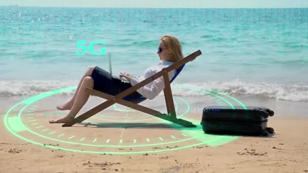 Concept de réseau futuriste. La technologie. Numérisation des flux d'information. vitesse 5g ou 4g internet. Femme d'affaires travaillant sur un ordinateur portable assis sur une chaise longue au bord de la mer . — Video