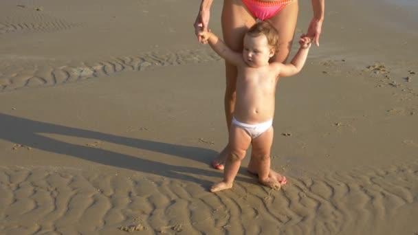 Blonde Baby kruipen op het zandstrand, moeder gelukkig kijkt naar haar — Stockvideo