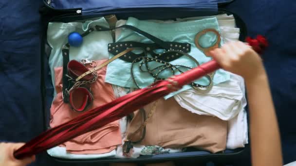 das Konzept des Sextourismus. In Großaufnahme sammelt eine Frau einen Koffer ein und legt das Gerät hinein..