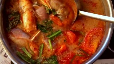 Kızlar scooping Tom yum çorbası yemek masası üzerinde el..
