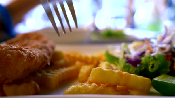 감자 튀김 및 샐러드를 곁들인 치킨 닭 꼬치 레스토랑에서 포크와 감자 튀김을 먹는 사람. — 비디오