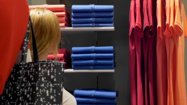 Concepto de venta, moda, consumismo mujer elegir ropa en el centro comercial, tienda de ropa — Vídeos de Stock