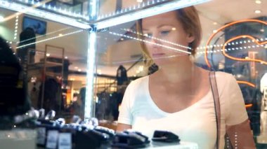 yakın çekim, kadın takı bir cam vitrin aracılığıyla bakar.