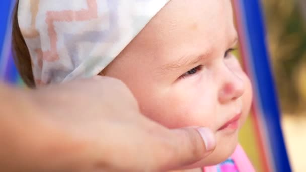 Gros plan, portrait d'une petite fille d'un an sur la plage . — Video