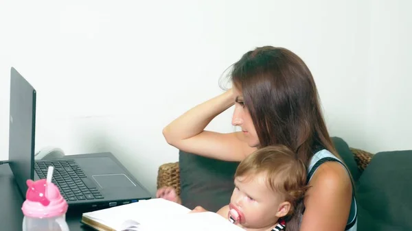 여성 프리랜서의 개념 작동 합니다. 현대 어머니입니다. 작업 테이블에 아이와 어머니입니다. 노트북에서 작업 하는 동안 그녀의 팔에는 우는 아이와 피곤, 실망 어머니. — 스톡 사진