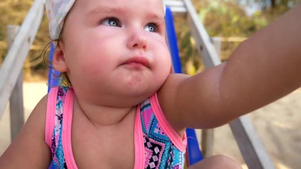 Gros plan, portrait d'une petite fille d'un an sur la plage . — Video