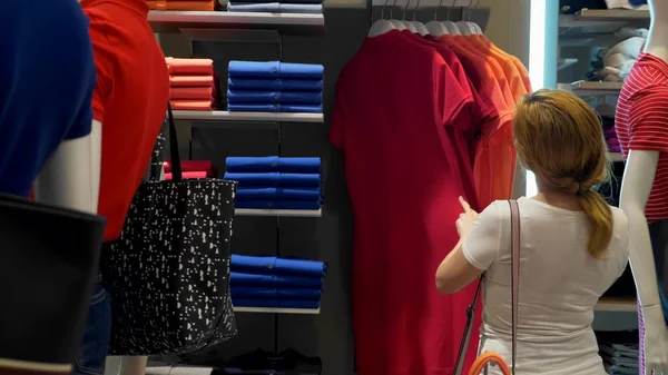 Concept van verkoop, mode, consumentisme kiezen kleding van de vrouw in winkelcentrum, kleding opslaan — Stockfoto