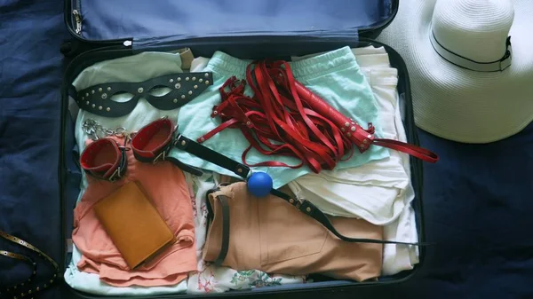 The concept of sex tourism. close-up, a woman collects a suitcase and puts into it the BDSM device. — Stock Photo, Image