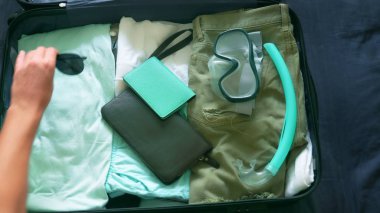 yakın çekim. adam bir bavul için tropikal ülkelerde denizde dalış ekipmanı ile seyahate toplar