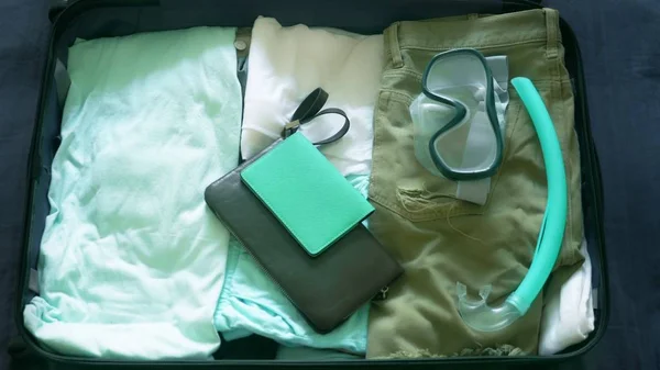 Gros plan. homme recueille une valise lors d'un voyage dans les pays tropicaux avec des équipements de plongée dans la mer — Photo