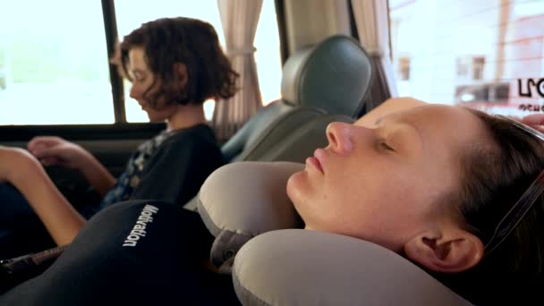 Road trip concept. woman in a neck pillow is resting in the car — Stock Video