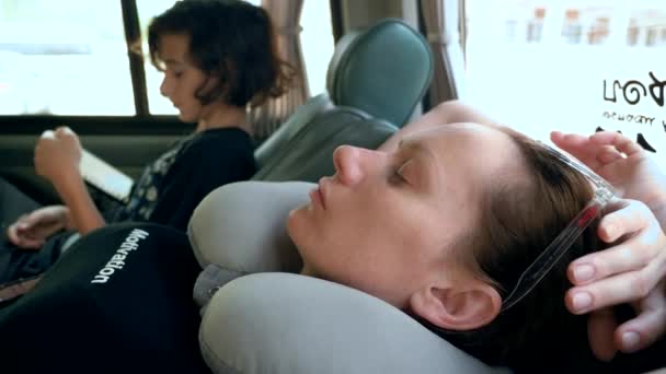 Concept de road trip. femme dans un coussin de cou repose dans la voiture — Video