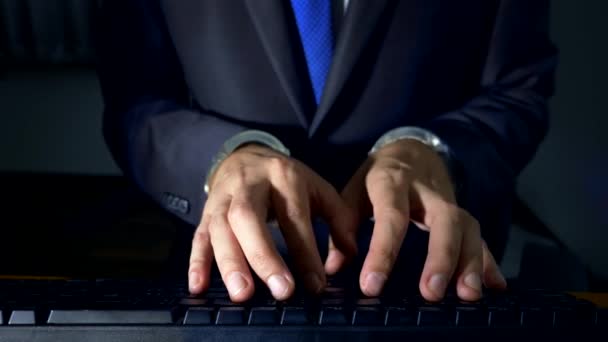 Gros plan, mains d'un homme d'affaires travaillant sur un clavier d'ordinateur menotté. concept de cybercriminalité, workaholism — Video