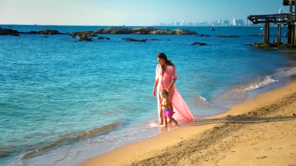 Blondynka, raczkowania na piaszczystej plaży, Mama wygląda szczęśliwie na nią — Wideo stockowe