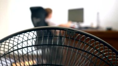 bulanık bir yazı masası, bir kişi bir bilgisayarda çalışır arka plan üzerine bir office fan parçası Close-Up