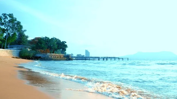 A playful handsome guy in a pink t-shirt and blue shorts joyfully runs into the sea. freak on the sea — Stock Photo, Image