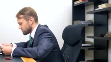 Ofis flört. Kırmızı tulum içinde çekici kadın iş arkadaşı ile masada flört derin bir yaka ile. Adam ofiste bir kadının göğsüne bakıyor