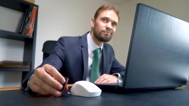 Homme d'affaires utilisant le lecteur flash se connecter à l'ordinateur portable sur le bureau . — Video