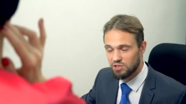 Ofis flört. adam yakın çekim kırmızı kıyafetler bir esmer konuşurken. meslektaşı ile flört.