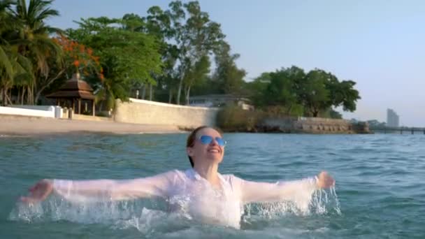 양복과 어두운 안경에 행복 한 비즈니스 여성이 럭셔리 리조트에서 바다에 튀는 것입니다. 대망의 휴가의 컨셉, 자유롭게. — 비디오