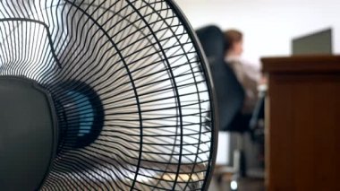 bulanık bir yazı masası, bir kişi bir bilgisayarda çalışır arka plan üzerine bir office fan parçası Close-Up