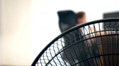 bulanık bir yazı masası, bir kişi bir bilgisayarda çalışır arka plan üzerine bir office fan parçası Close-Up