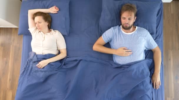 Concepto de problemas en un par. problemas sexuales. pareja, hombre y mujer disgustados están acostados en la cama. vista superior — Vídeo de stock