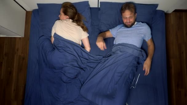 Conceito de problemas em um par. problemas sexuais. casal, homem e mulher descontentes estão deitados na cama. vista superior — Vídeo de Stock