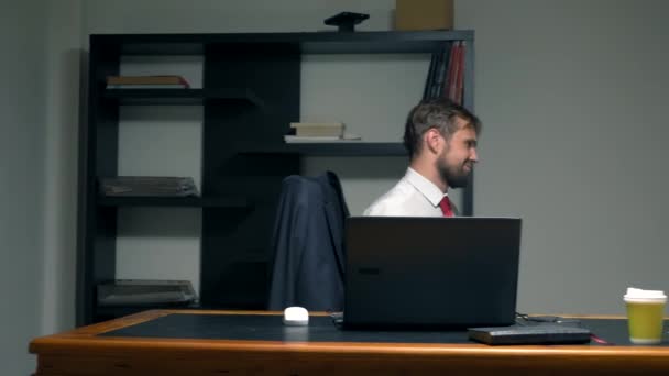 Office flirta. En attraktiv kvinna i en röd Jumpsuit med en djup urringning kommer in på kontoret till mannen, han tar henne i armarna och sätter på bordet, kysser. — Stockvideo