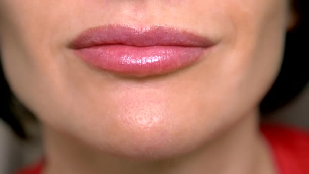 Súper cerca. labios femeninos con brillo labial, sonrisa. enfermedad dermatológica de los labios mucosos, gránulos de Fordyce — Vídeo de stock