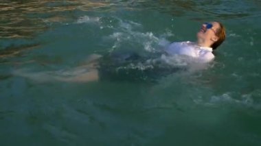 Suit ve koyu gözlük mutlu iş kadın lüks tatil denizde sıçrama olduğunu. Uzun zamandır beklenen tatil kavramı, freelancing.