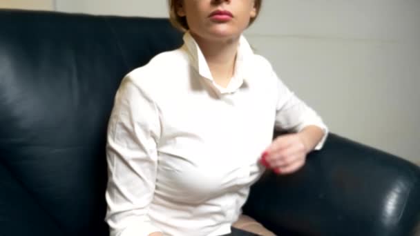 Μια γυναίκα επιχείρηση με λευκή μπλούζα και κόκκινο μανικιούρ αποσυμπιά το πουκάμισό της, και ενεργοποιεί το κλιματιστικό με ένα τηλεχειριστήριο. Γκρο πλαν — Αρχείο Βίντεο