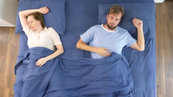 Concetto di problemi in una coppia. problemi sessuali. coppia, uomo e donna scontenti sono sdraiati a letto. vista dall'alto — Video Stock