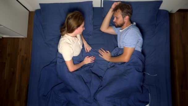 Concept of problems in a pair. sexual problems. couple, displeased man and woman are lying in bed. top view — Stock Video