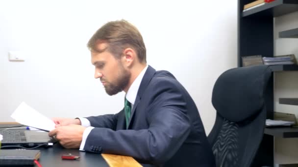Офис флиртует. Привлекательная женщина в красном комбинезоне с глубоким вырезом, флиртующая за столом со своим коллегой. мужчина смотрит на сундук женщины в офисе — стоковое видео