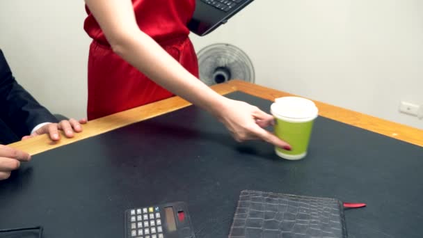 La oficina coquetea. Una mujer atractiva en un mono rojo pone su portátil en el escritorio de su prójimo . — Vídeo de stock