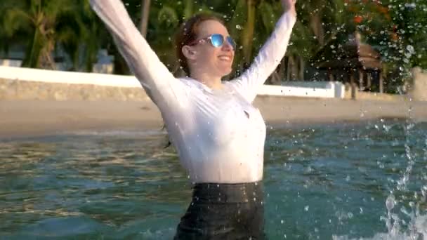 Mujer de negocios feliz en traje y gafas oscuras está salpicando en el mar en resorts de lujo. El concepto de unas vacaciones tan esperadas, freelancing . — Vídeo de stock